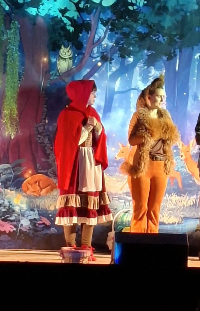 Czerwony Kapturek i postać lisa na bajkowej leśnej scenie